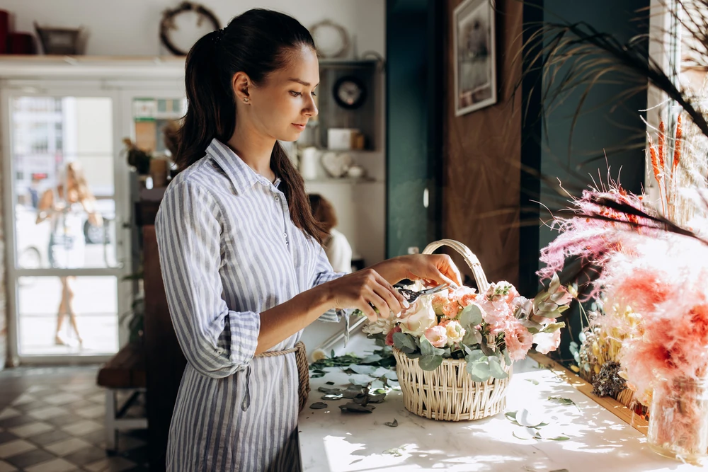 Women arranging flowers in kitchen